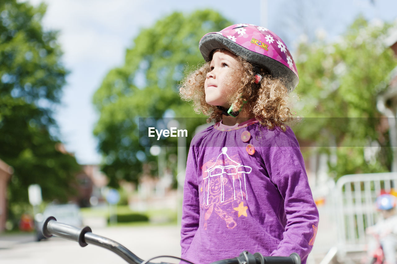 Girl in safety helmet standing in street