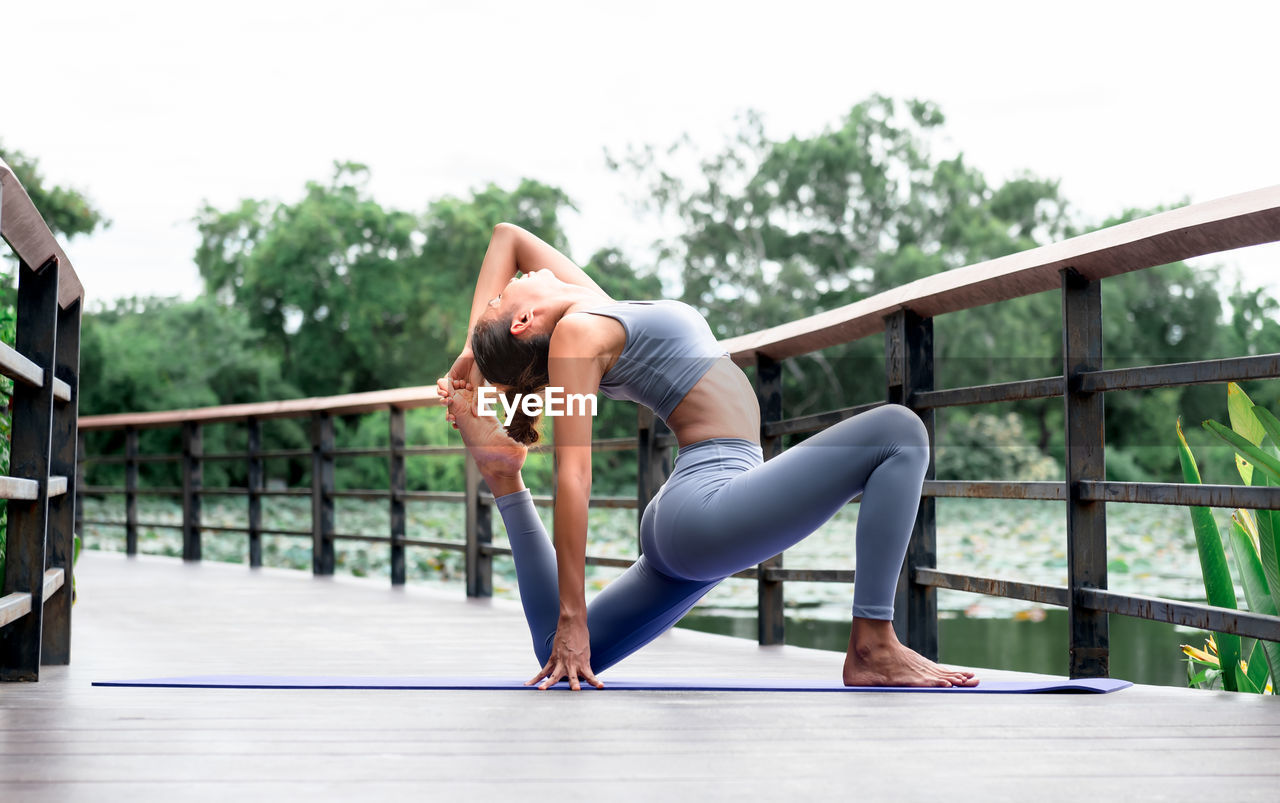 WOMAN SITTING ON RAILING