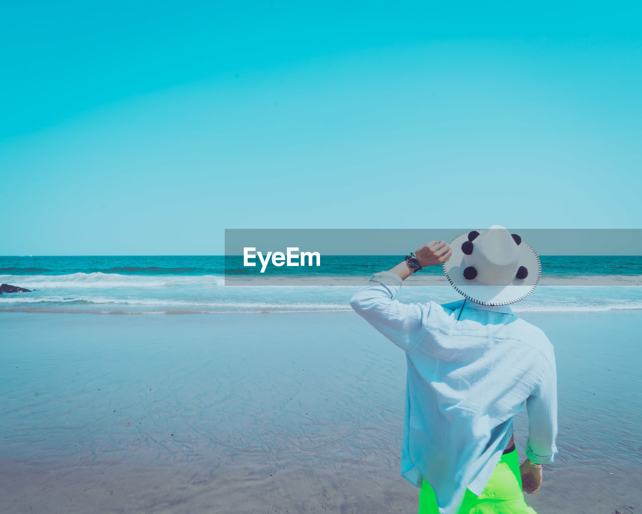 FULL LENGTH OF MAN STANDING ON BEACH AGAINST CLEAR SKY