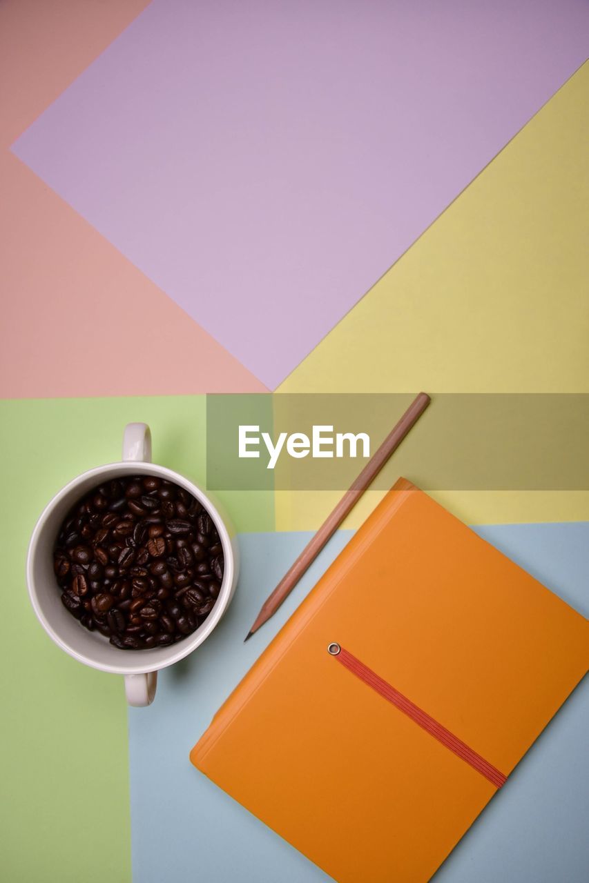 HIGH ANGLE VIEW OF COFFEE CUP ON TABLE AGAINST WALL