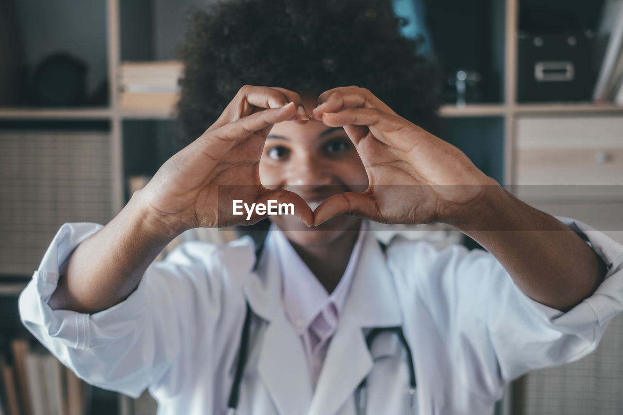 Doctor making heart gesture in clinic