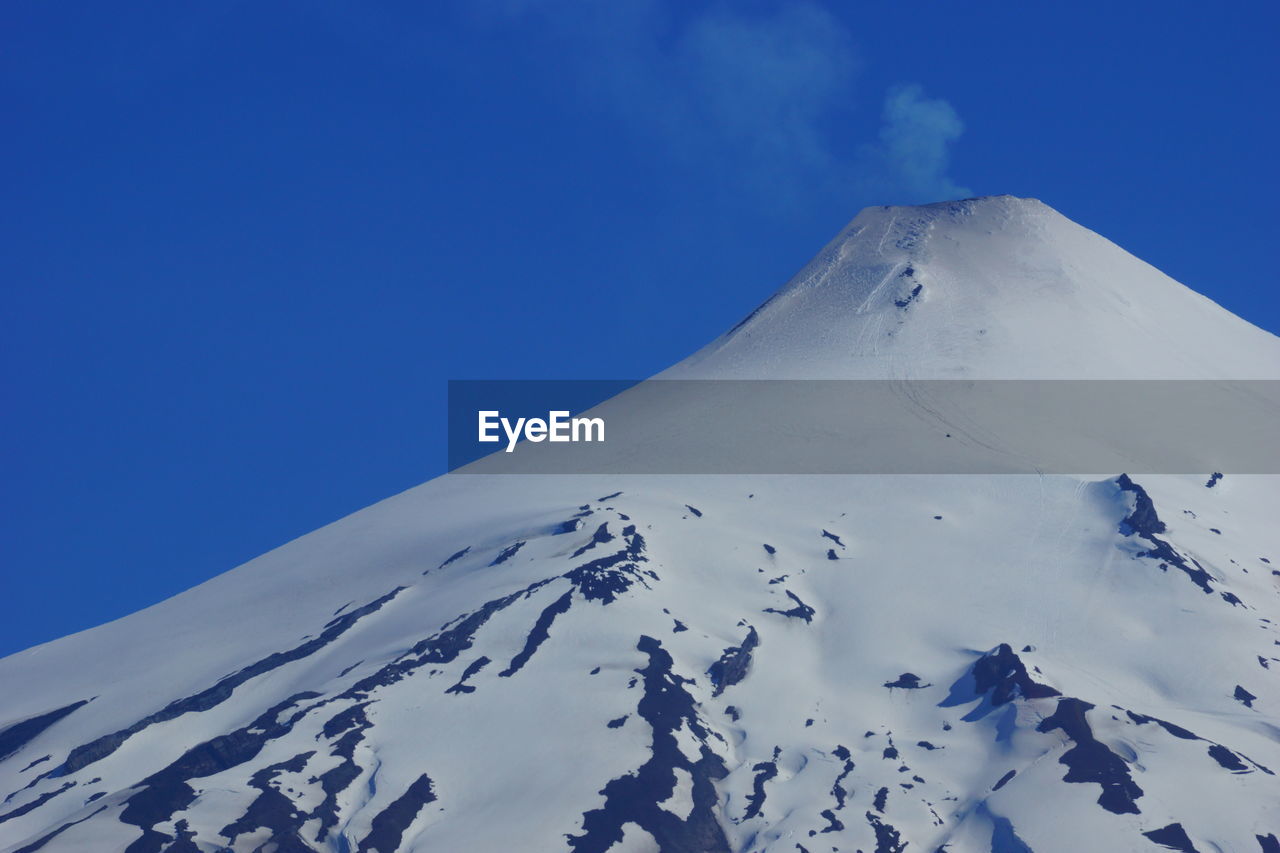 Scenic view of snowcapped mountains against clear blue sky