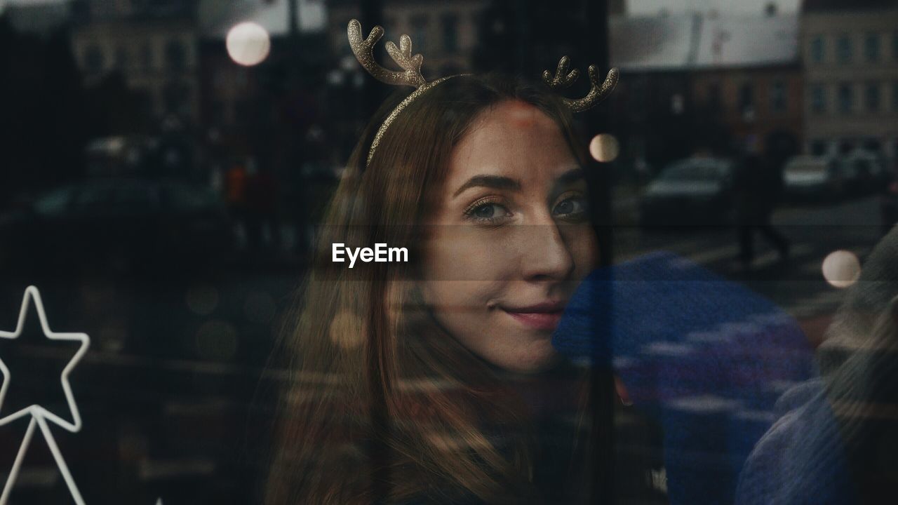 Close-up of young woman looking through window