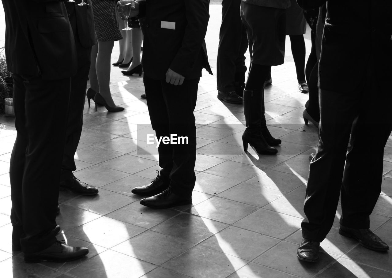 LOW SECTION OF PEOPLE STANDING ON CORRIDOR