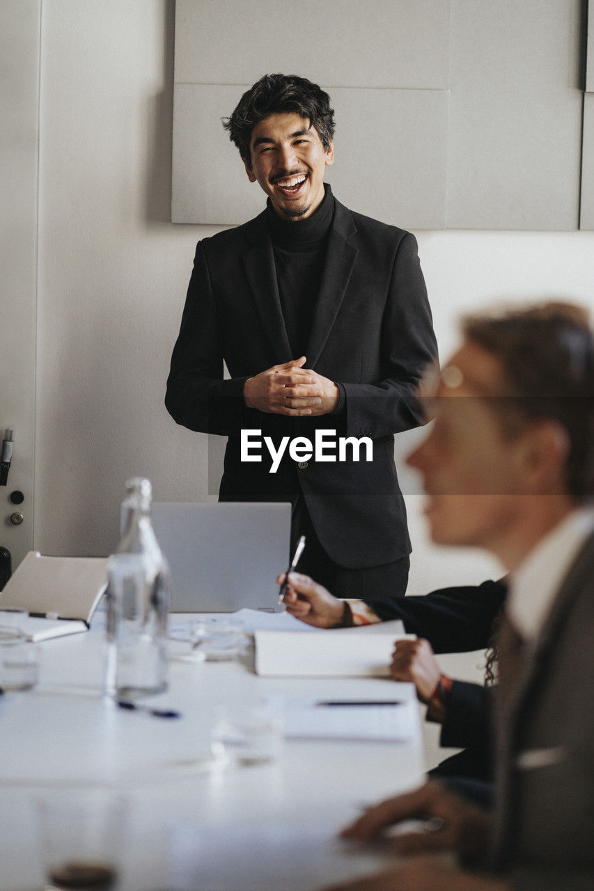 Happy businessman with hands clasped during business meeting at office