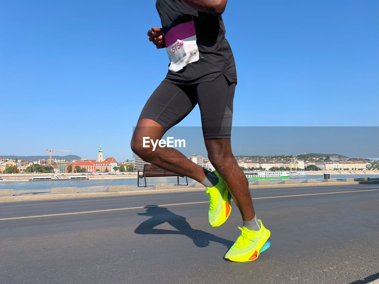 sports, adult, one person, exercising, sky, lifestyles, clothing, running, motion, person, sports clothing, day, footwear, athlete, vitality, nature, full length, clear sky, men, city, sports training, recreation, jogging, blue, endurance sports, sunlight, water, road, activity, leisure activity, human leg, outdoors, sunny, shoe, sea, copy space, player, determination, young adult, transportation, land, architecture, limb, track and field event, side view