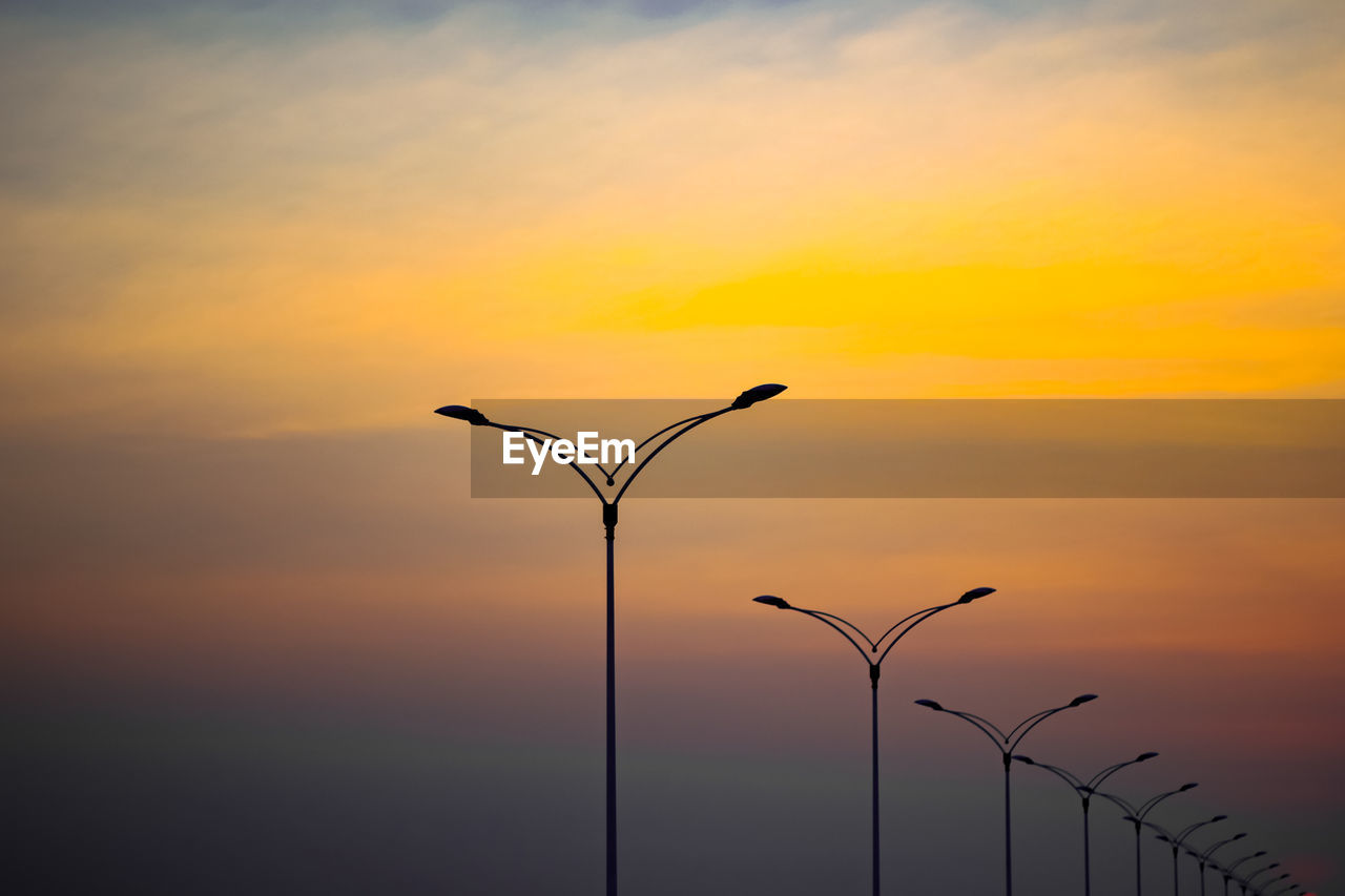 Low angle view of street light against orange sky