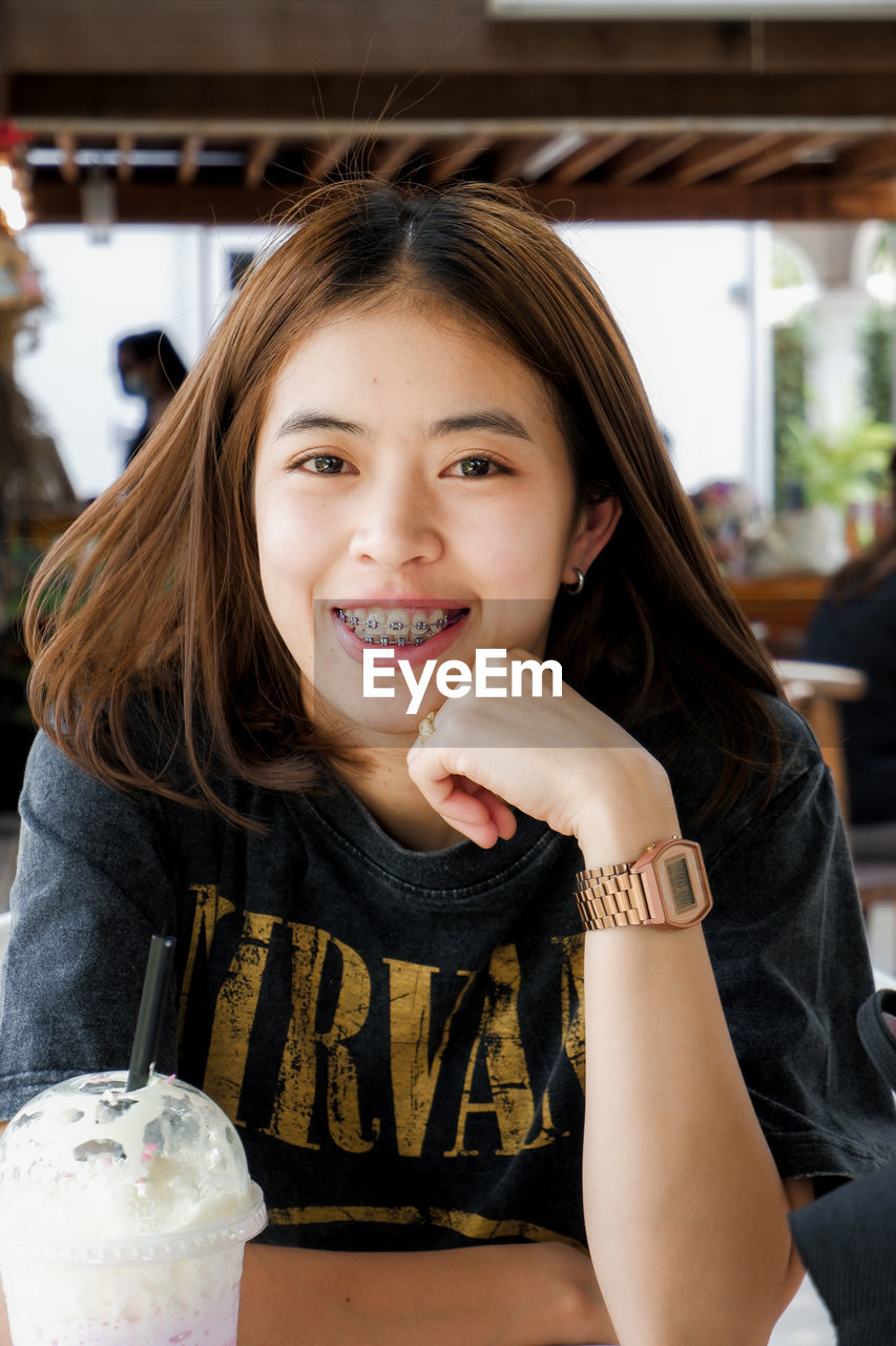 PORTRAIT OF A SMILING GIRL IN A ROOM