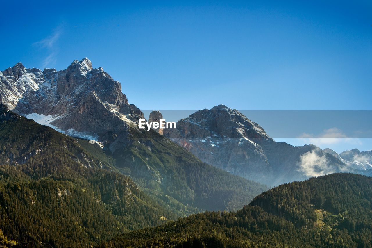 Scenic view of rocky mountains against blue sky