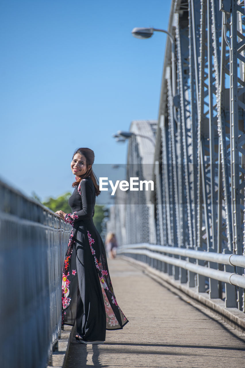 Beautiful woman walking over truong tien bridge in hue / vietnam