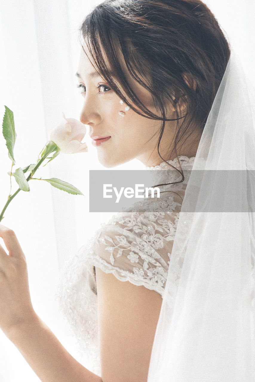 Side view of bride holding flower