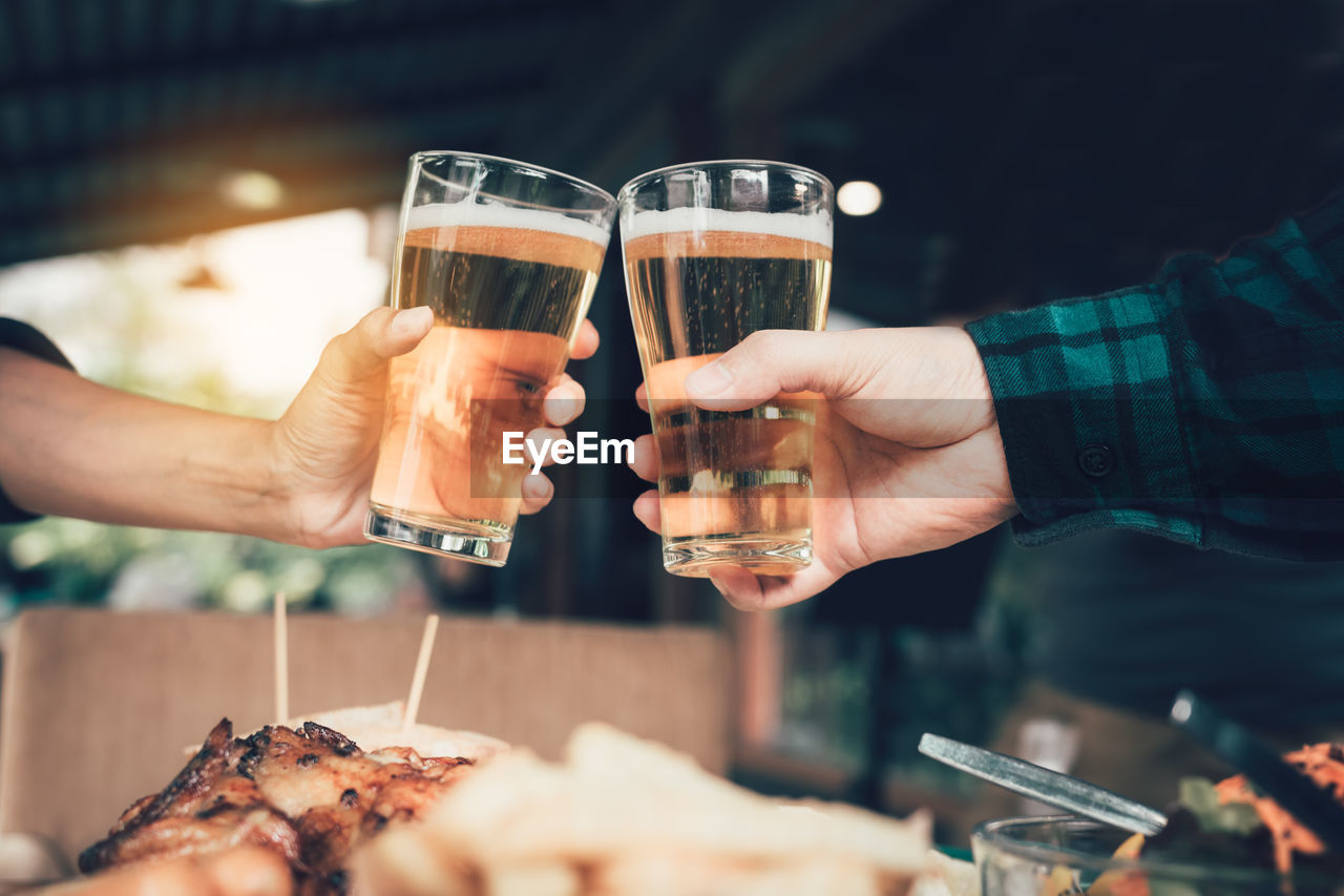 Close-up of friends toasting drinks at table