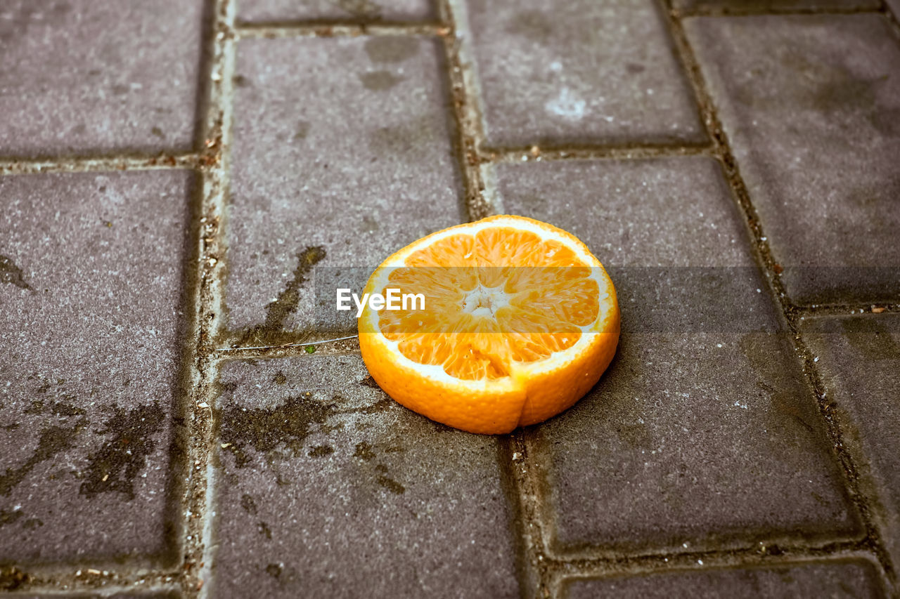 A slice of orange on the sidewalk