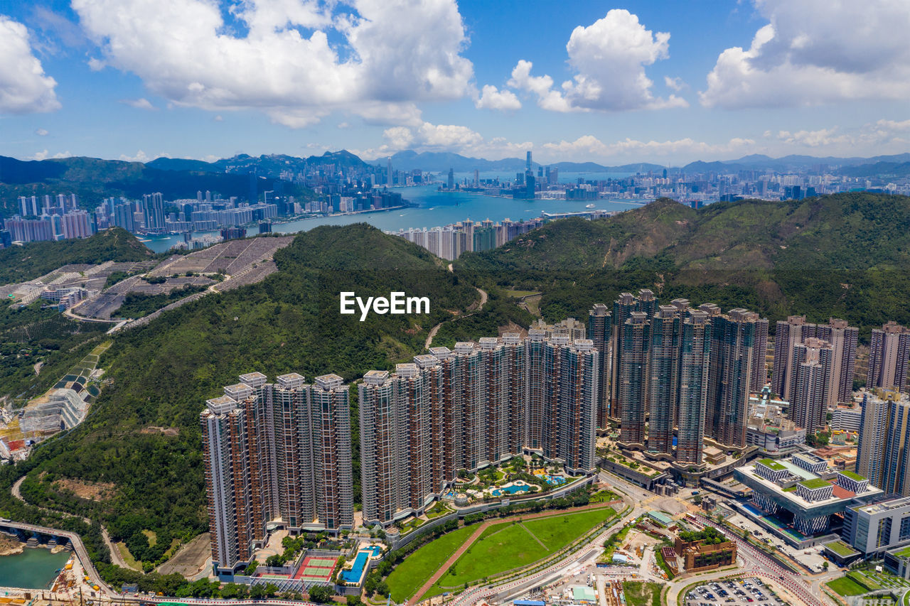 HIGH ANGLE VIEW OF BUILDINGS AGAINST CLOUDY SKY