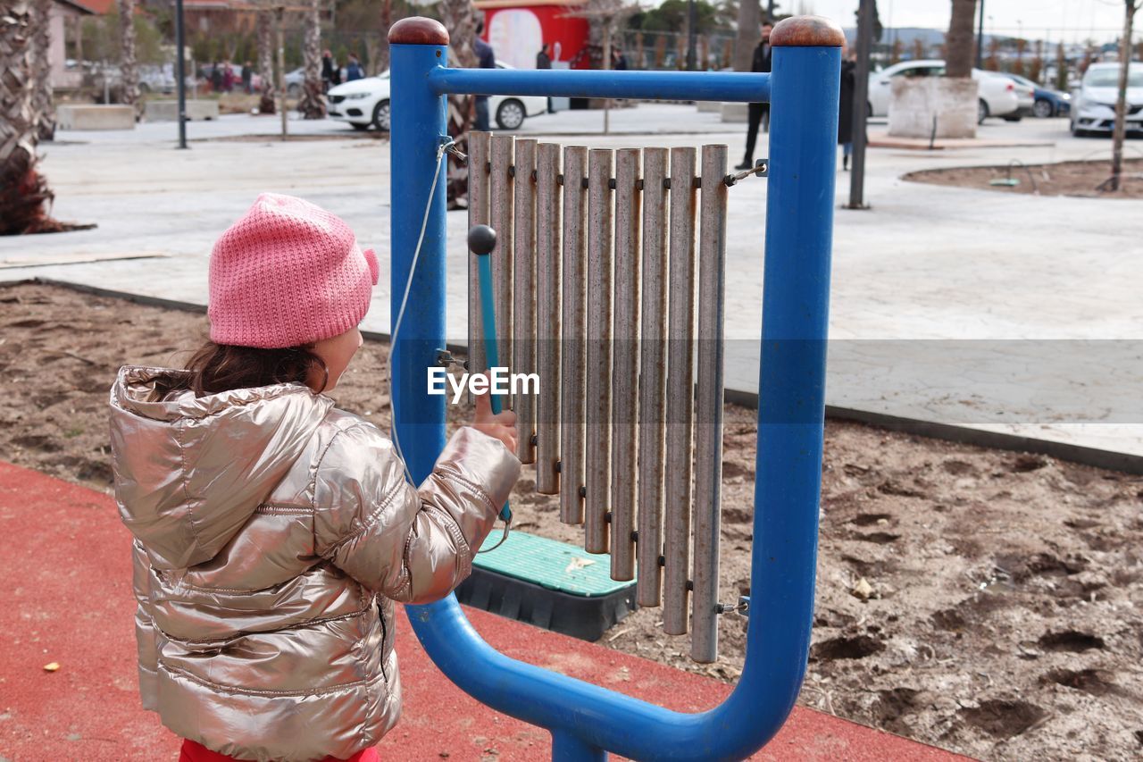 Girl playing large musical instrument at playground