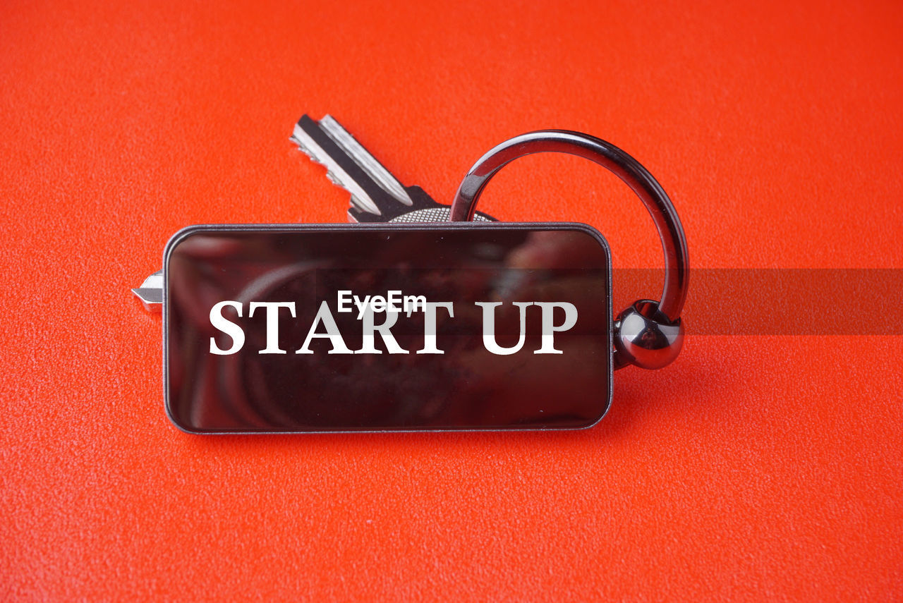 Close-up of text over key ring against red background