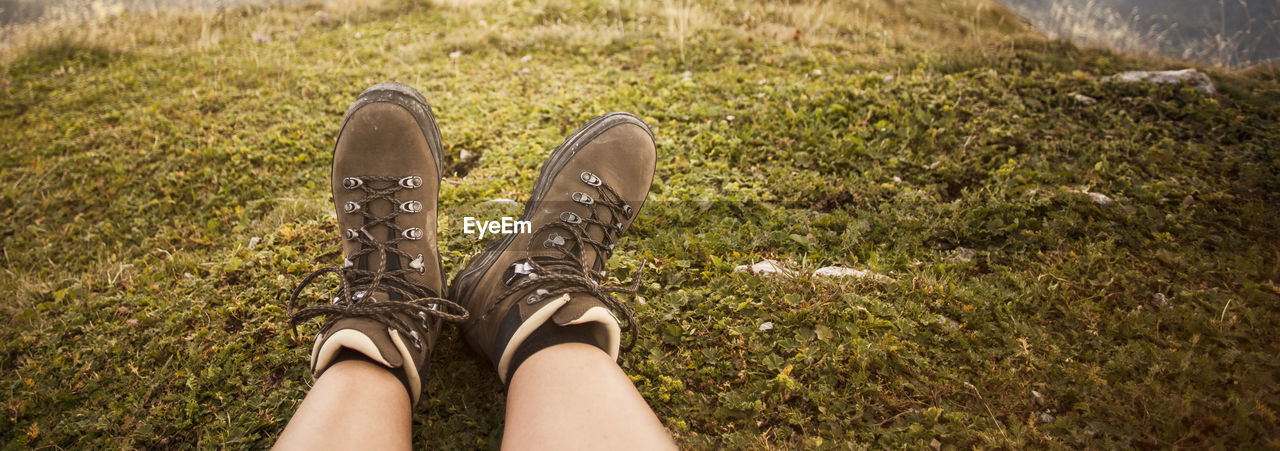 shoe, human leg, low section, grass, personal perspective, one person, lifestyles, nature, plant, limb, human limb, leisure activity, footwear, high angle view, land, human foot, day, standing, adult, green, field, outdoors, spring, sunlight, relaxation, women, sandal, directly above, lawn, casual clothing