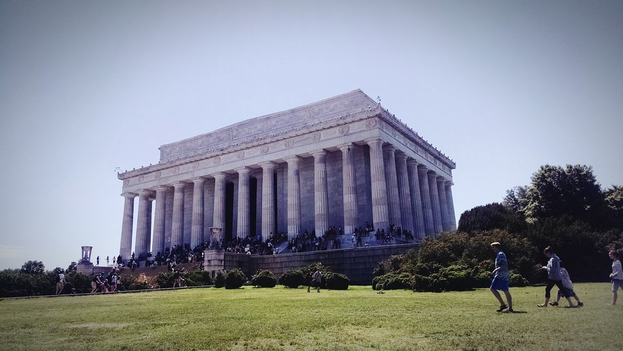 Low angle view of tourists at lincoln memorial against clear sky