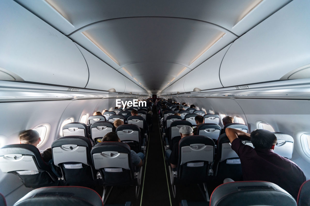 REAR VIEW OF PEOPLE IN AIRPLANE