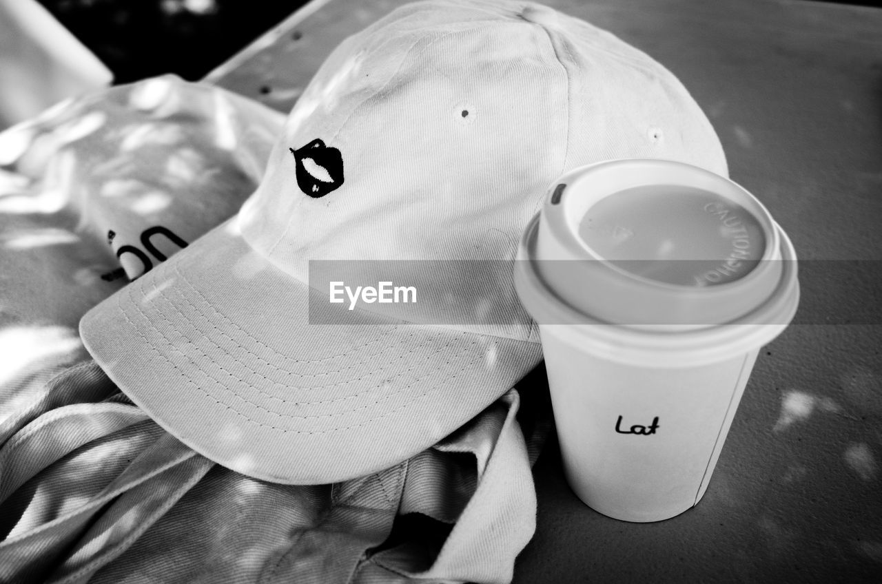 HIGH ANGLE VIEW OF COFFEE CUP WITH TEXT ON TABLE