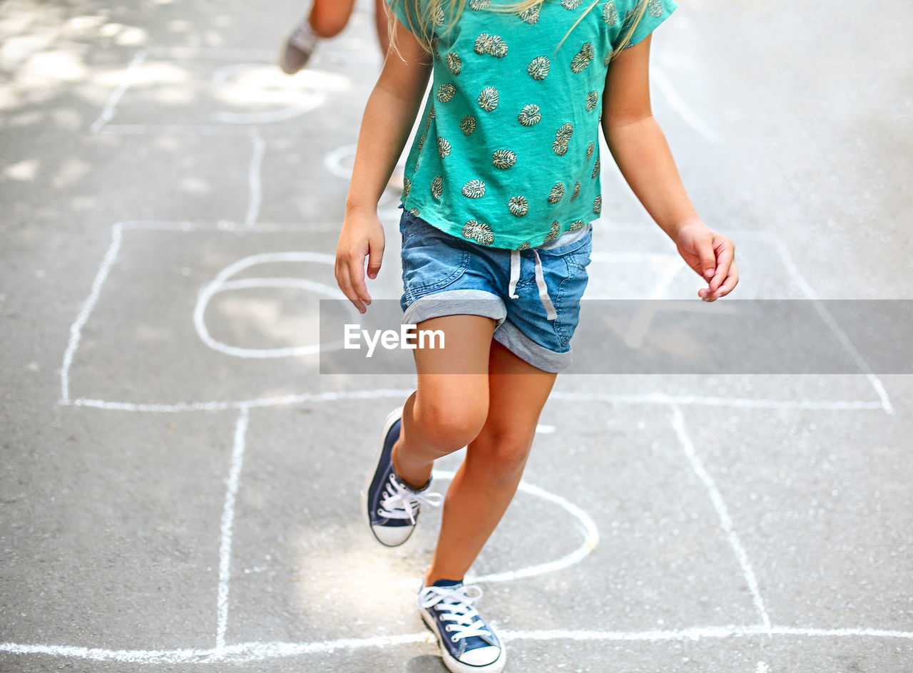 Low section of girl playing hopscotch