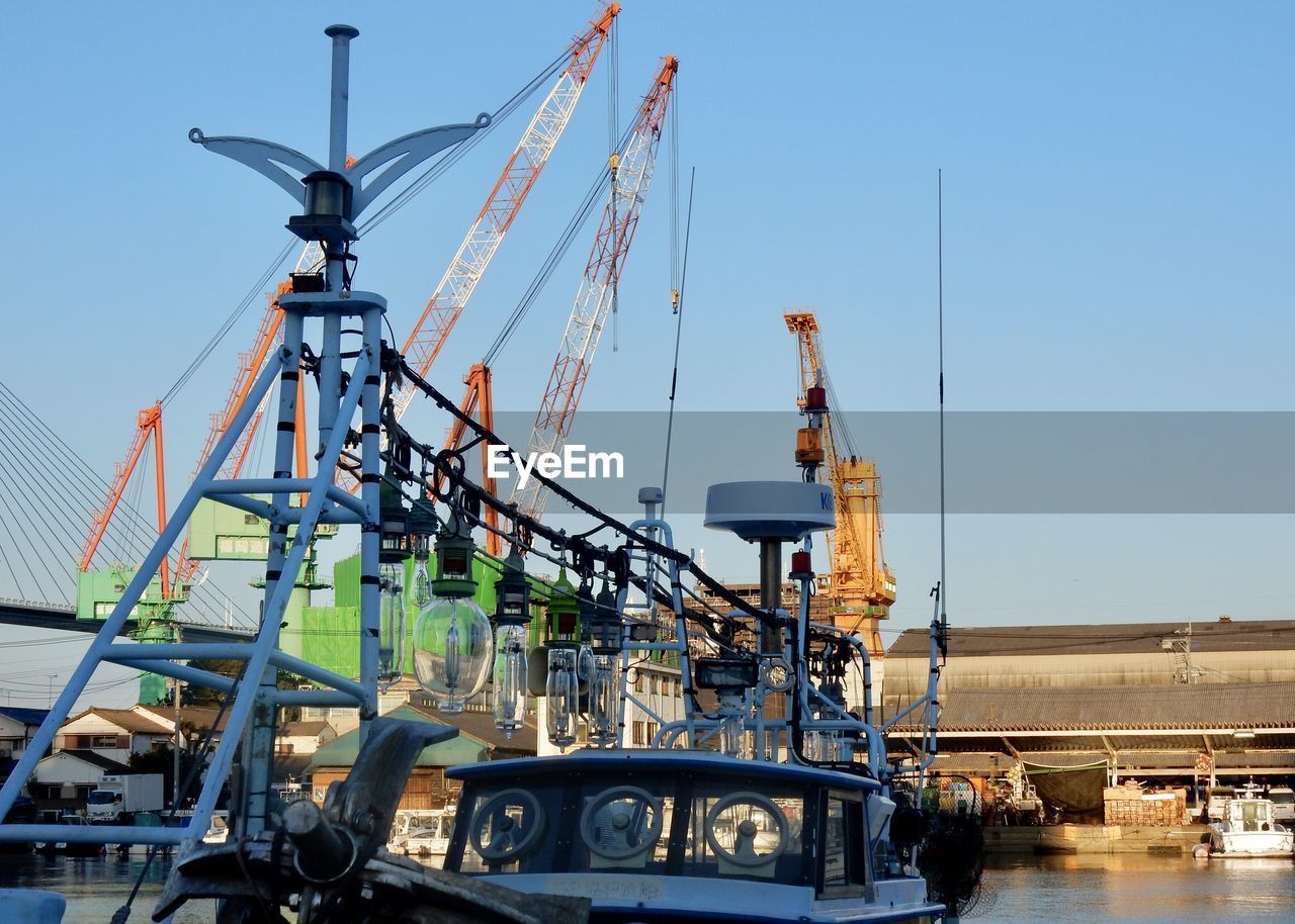 Low angle view of cranes against clear sky