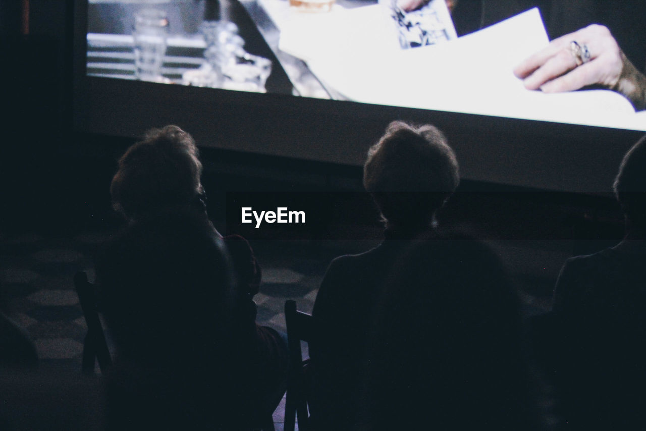 REAR VIEW OF PEOPLE SITTING ON TABLE IN CAFE