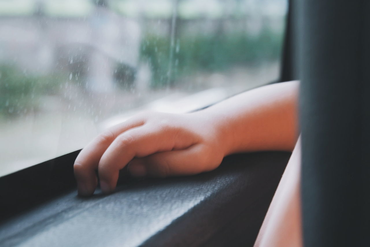 Cropped hand of child on window sill