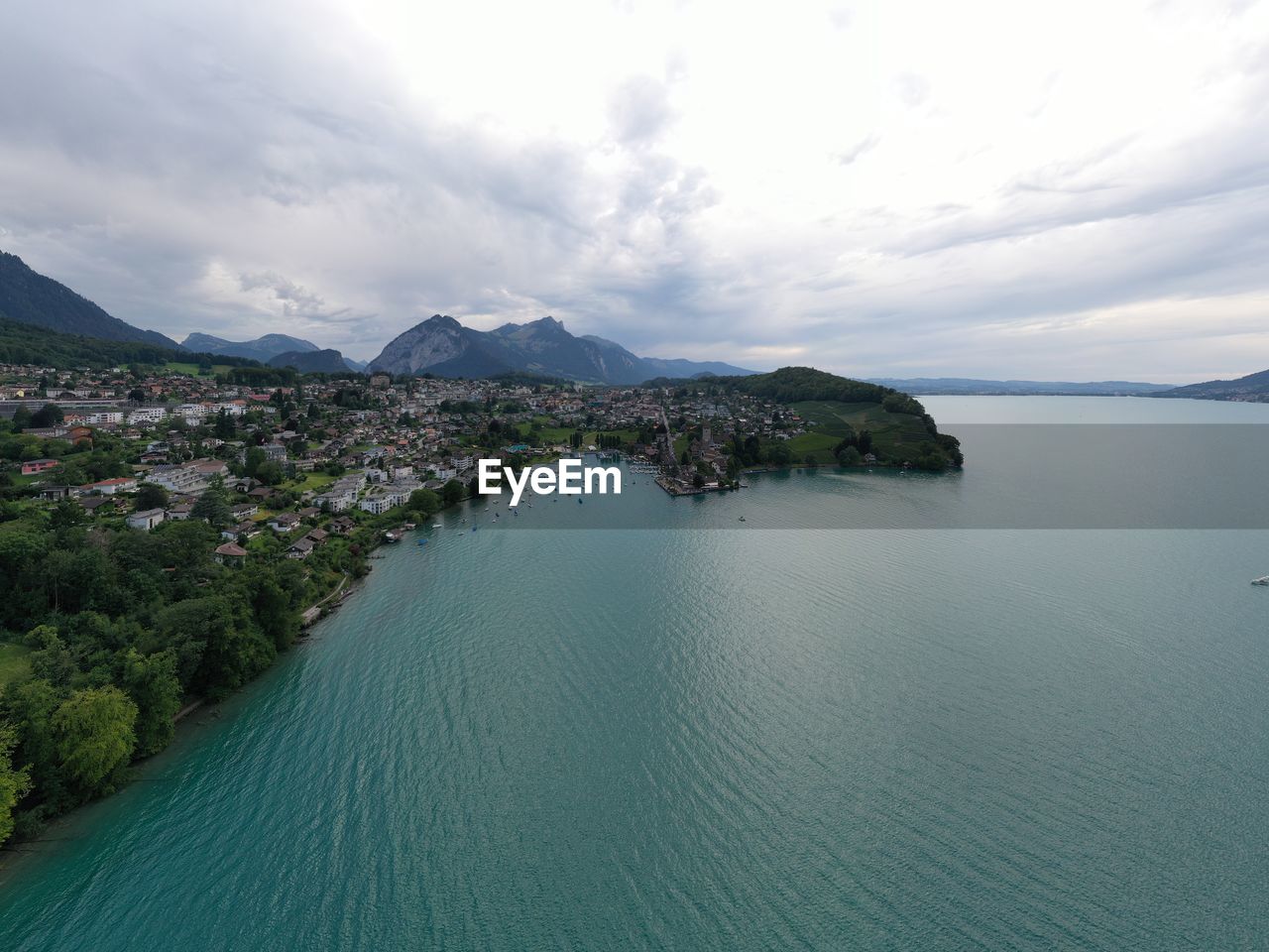 scenic view of sea by mountains against sky