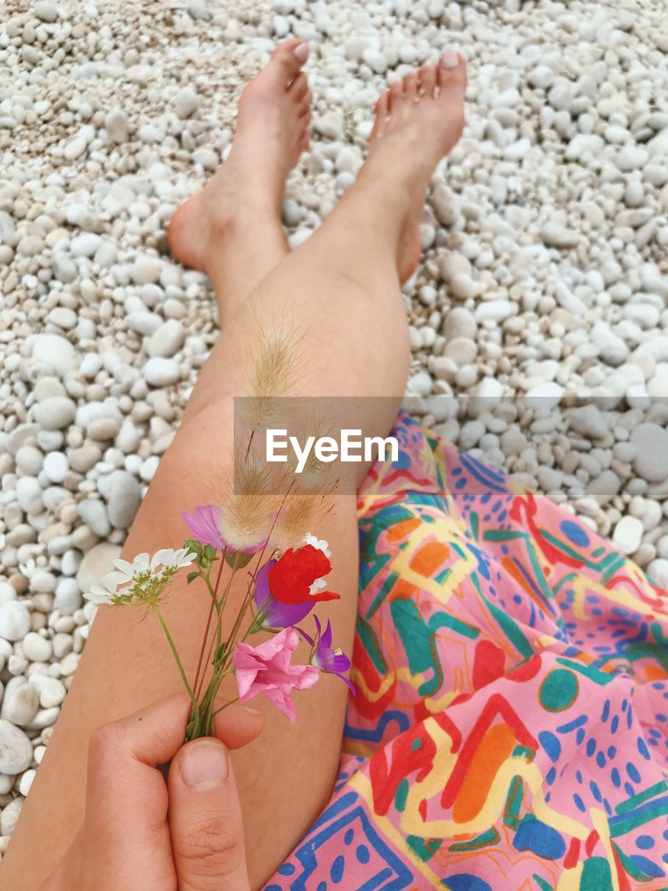 CLOSE-UP OF WOMAN HAND HOLDING PEBBLES