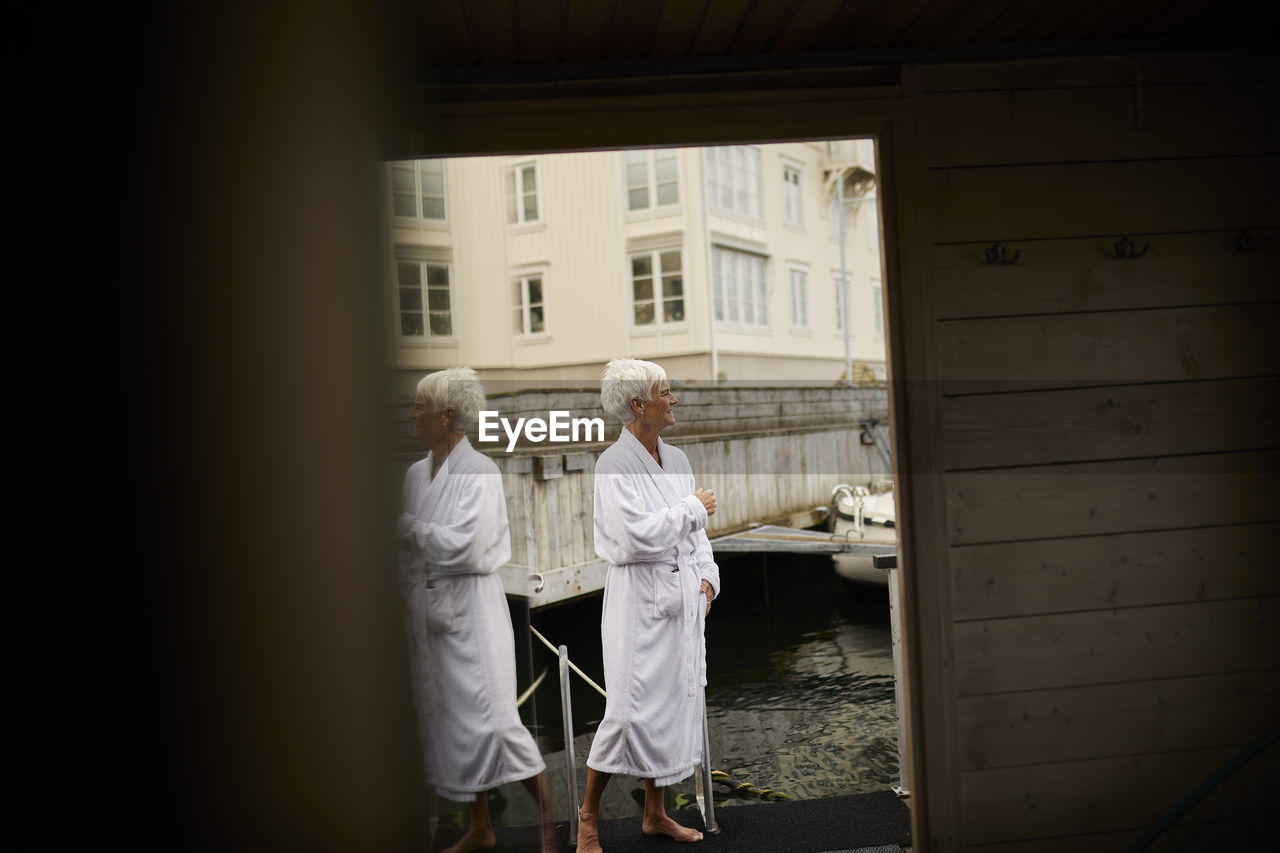 Senior woman wearing dressing gown at sea