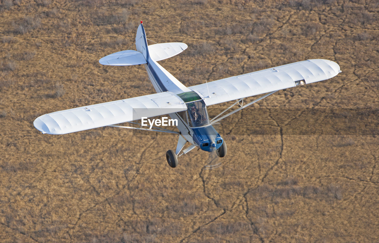 High angle view of airplane flying over land