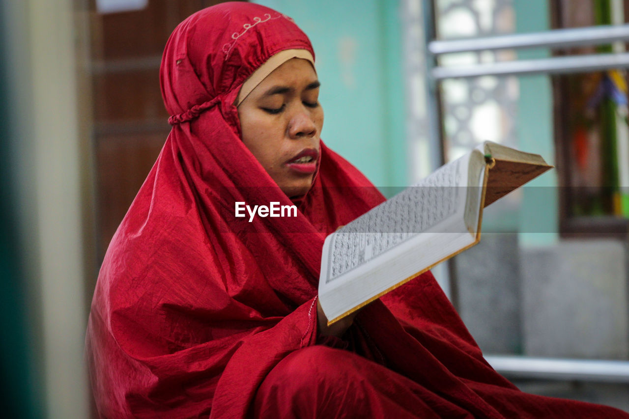 Young woman reading the qur'an book