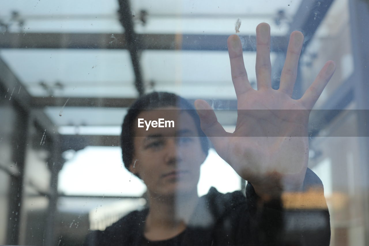 Close-up of man looking through glass window