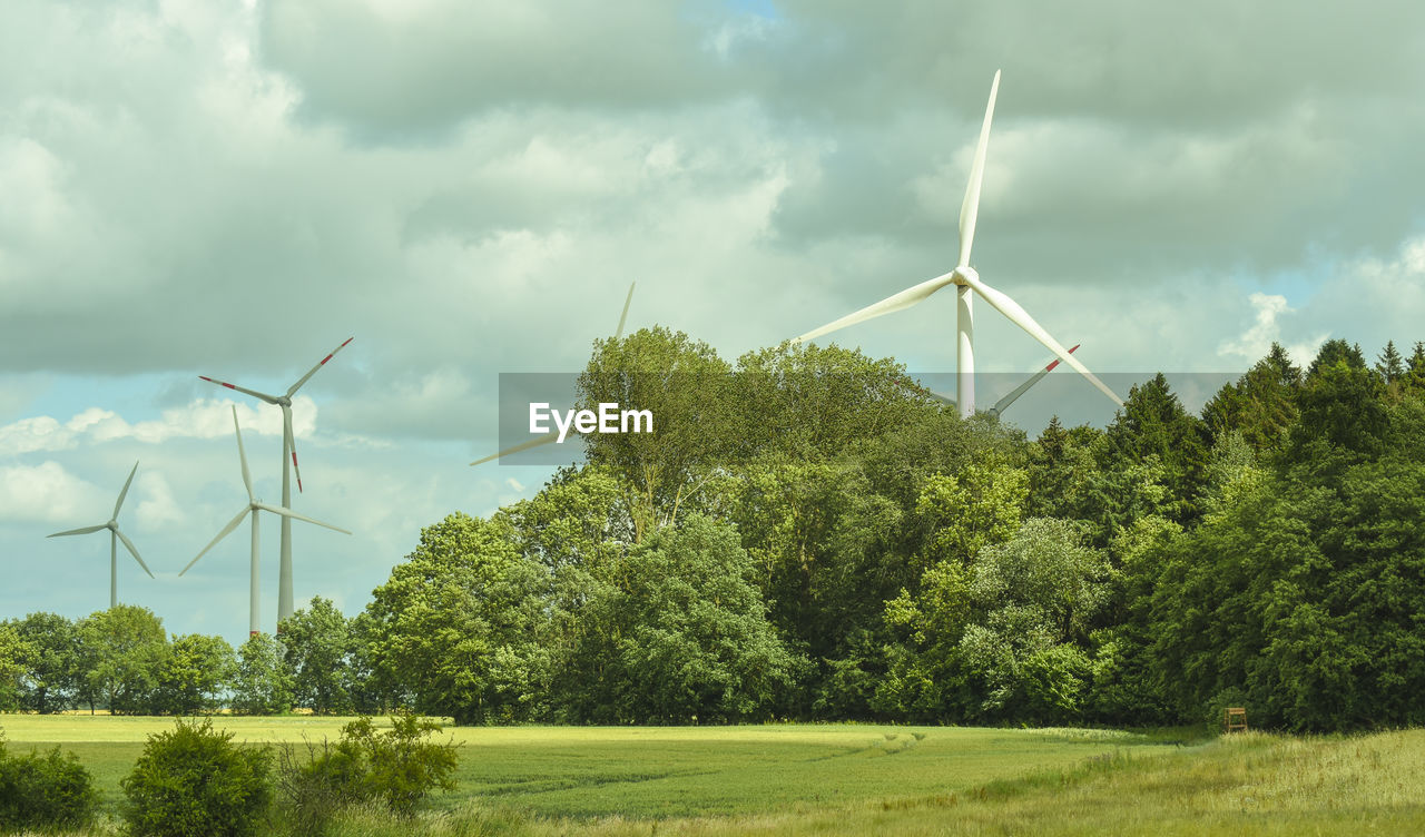 WIND TURBINES ON LAND AGAINST SKY