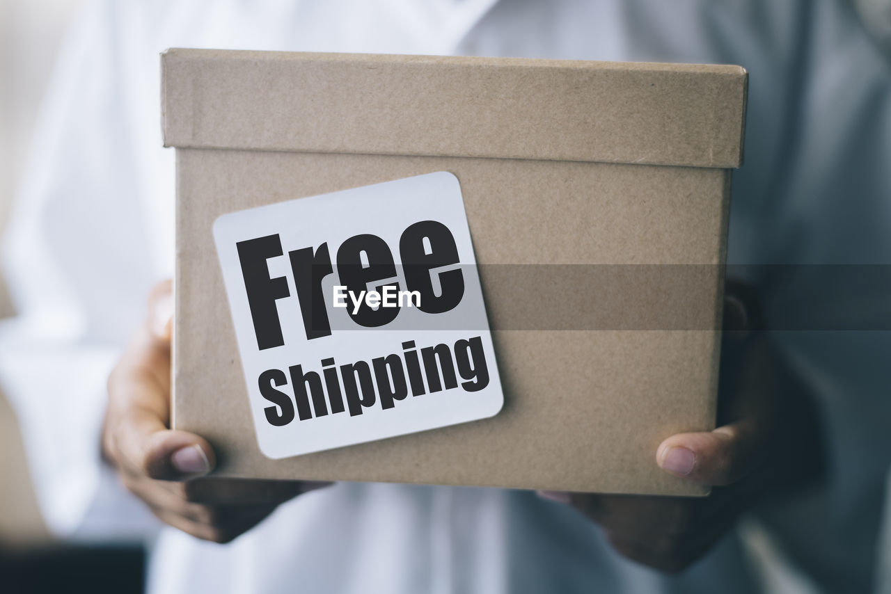 Cropped hands of boy holding cardboard box