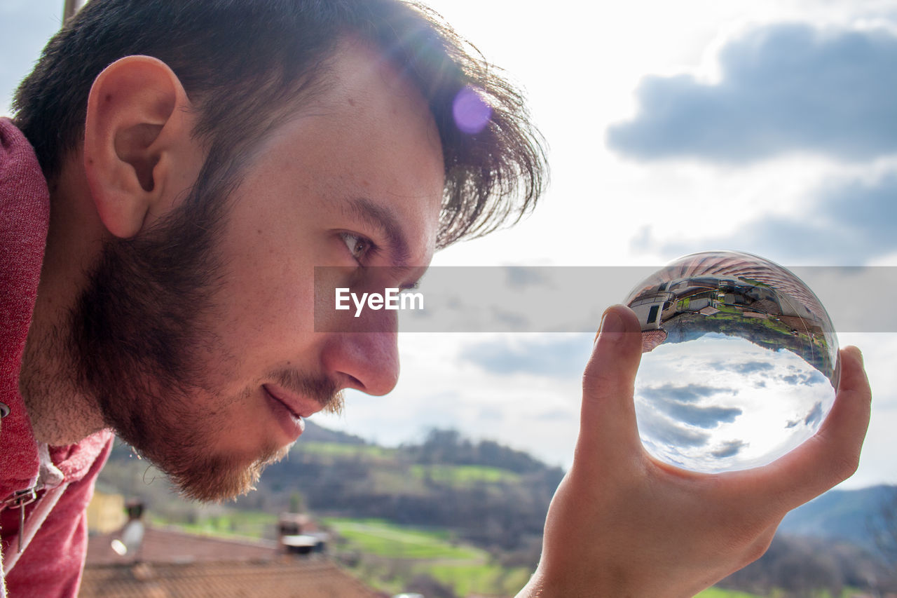 Close-up of young man holding crystal ball