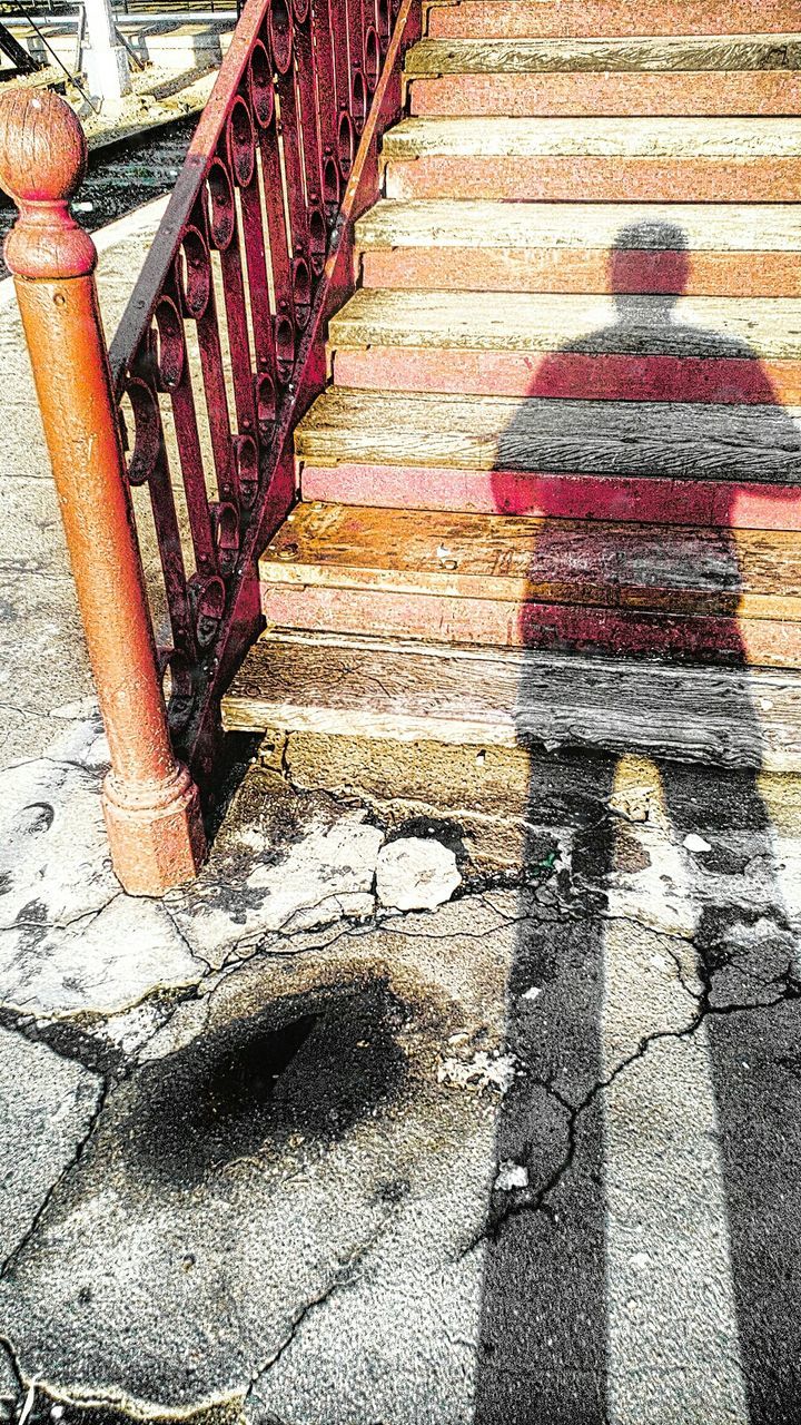 Shadow of man standing in front of staircase