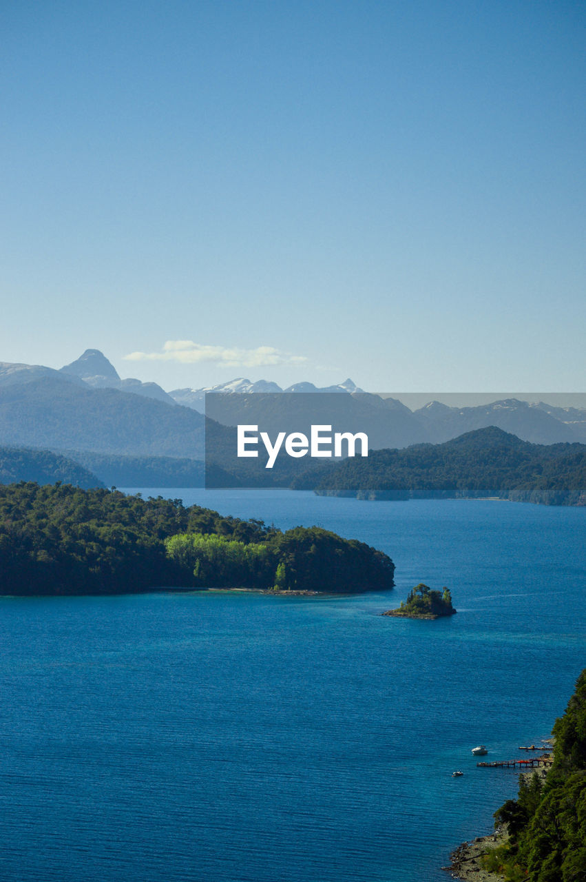 SCENIC VIEW OF SEA AND MOUNTAINS AGAINST CLEAR SKY
