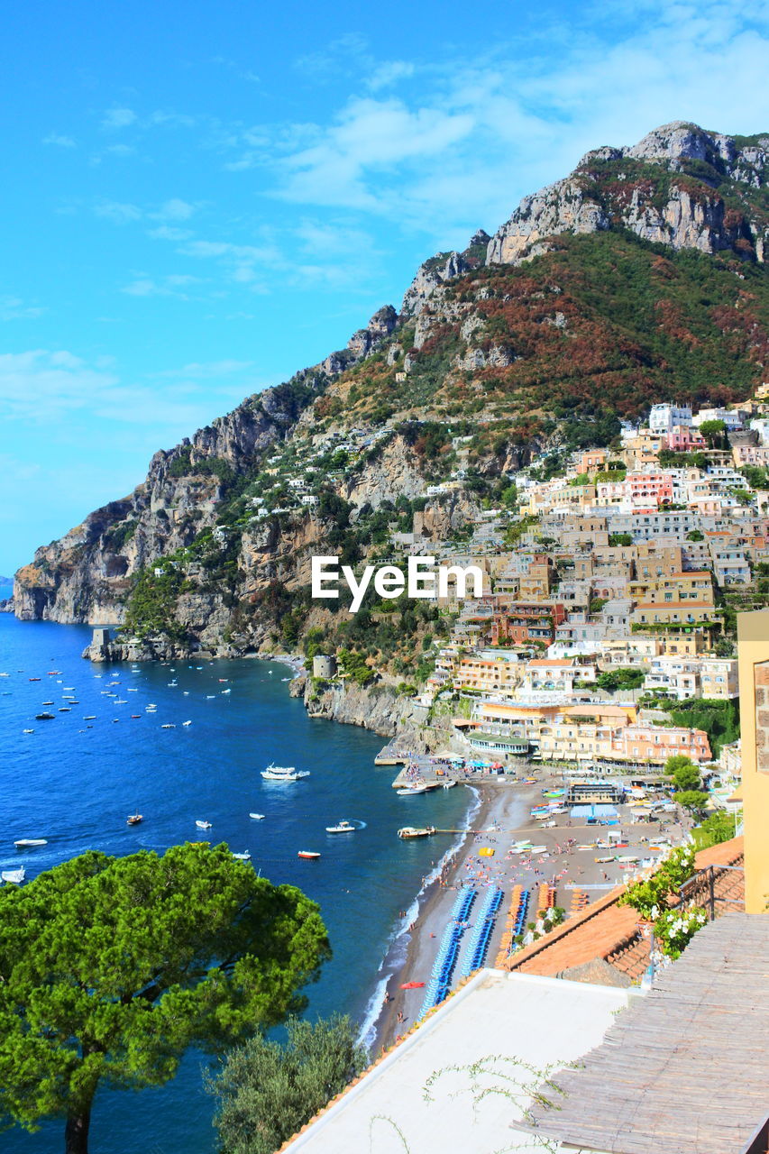 Scenic view of sea and mountains against blue sky