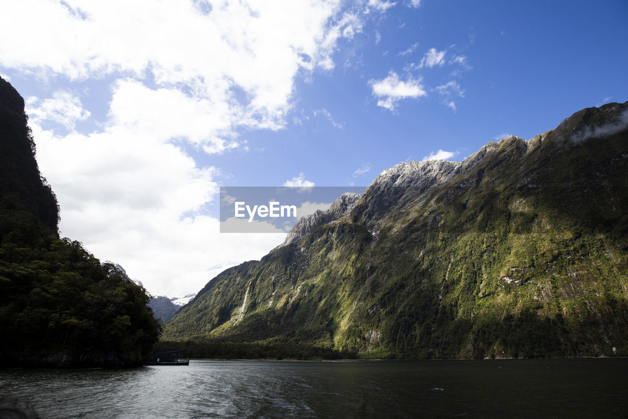 Scenic view of lake by mountains against sky