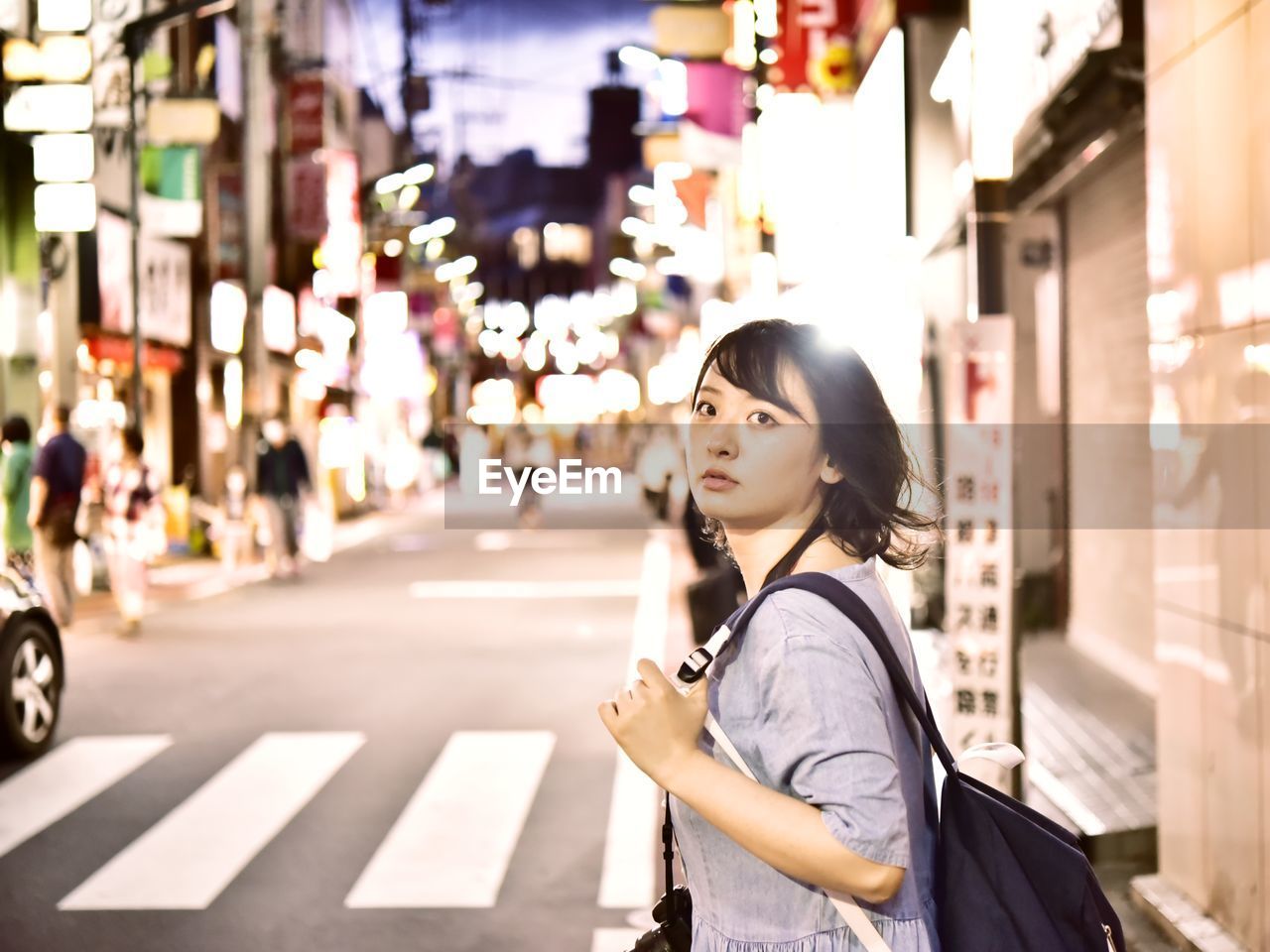 Young woman standing on street in city