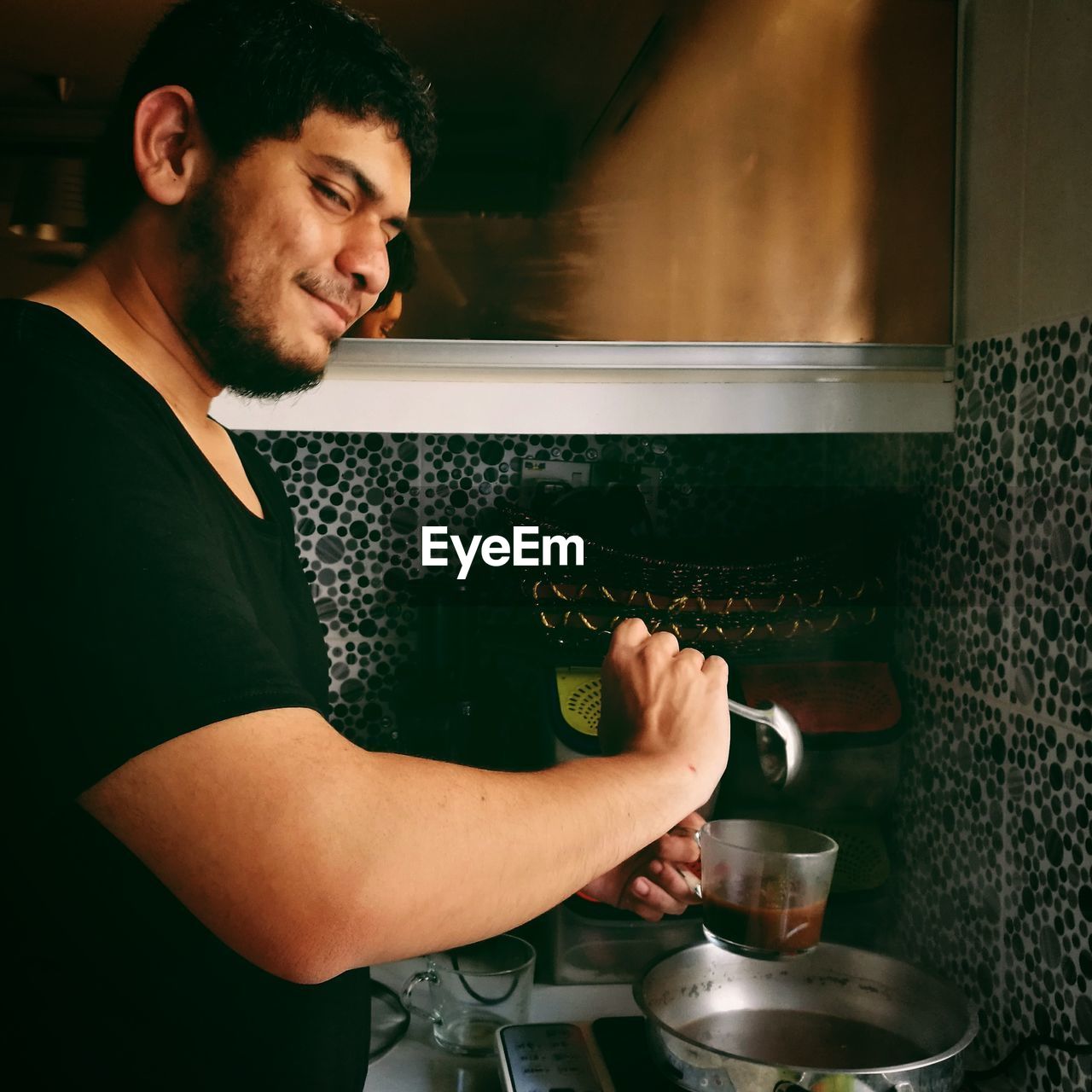 Side view portrait of man preparing food in kitchen