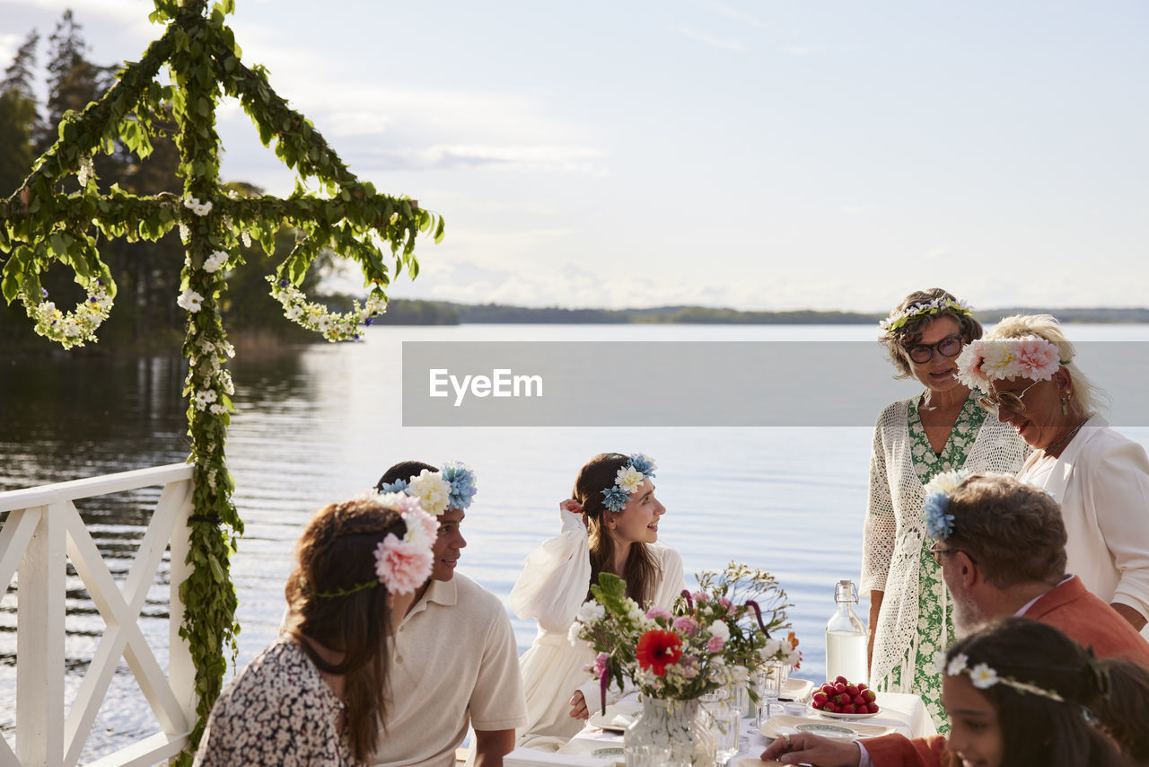 Family having midsummer dinner by lake