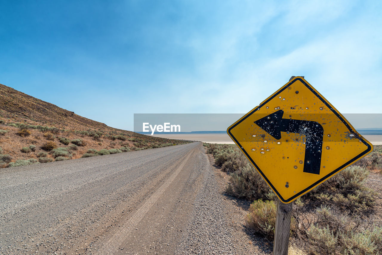 ROAD SIGN AGAINST BLUE SKY