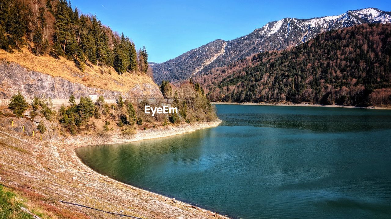 SCENIC VIEW OF LAKE BY MOUNTAIN AGAINST SKY