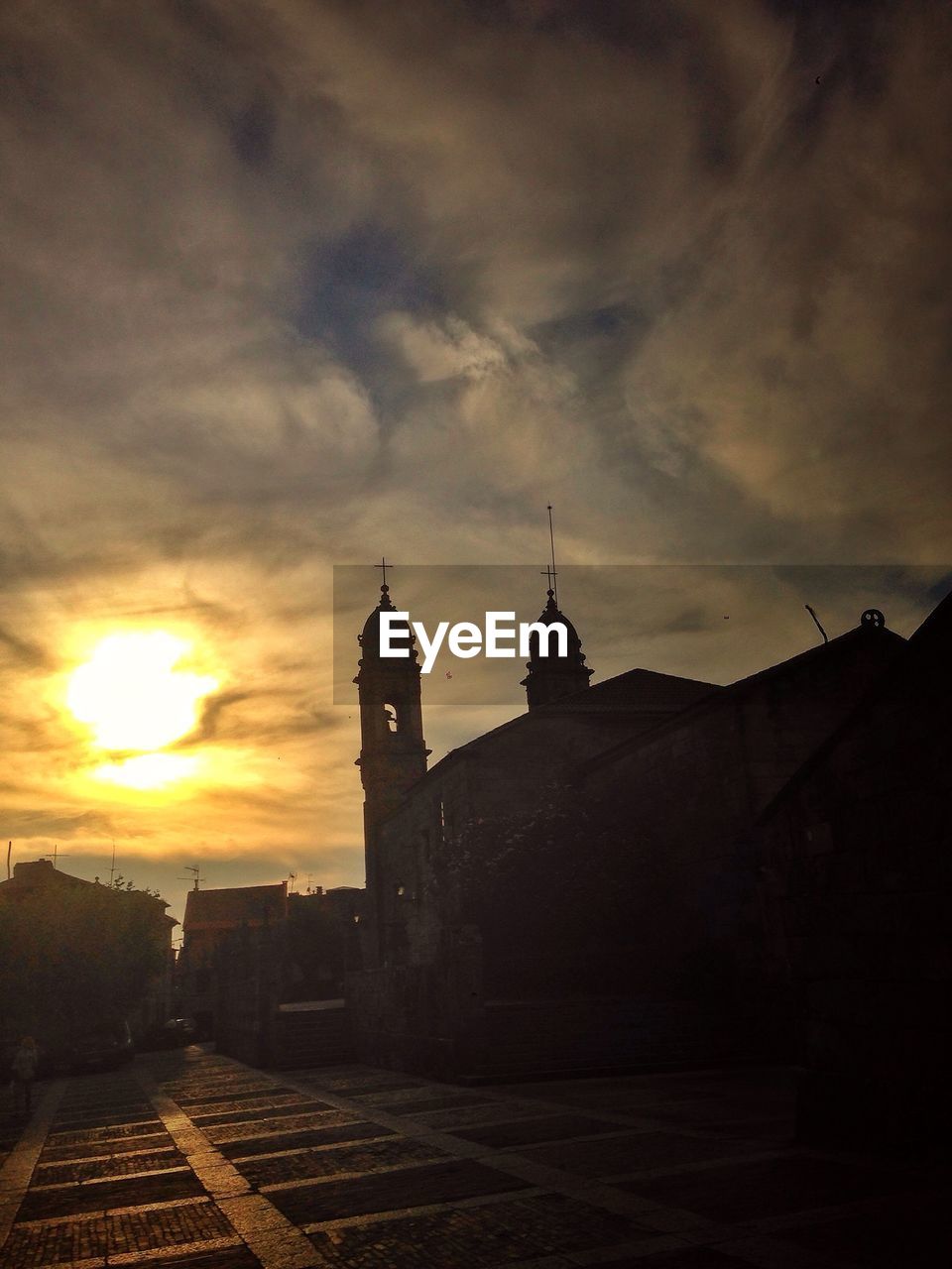 Low angle view of silhouette church against cloudy sky during sunset