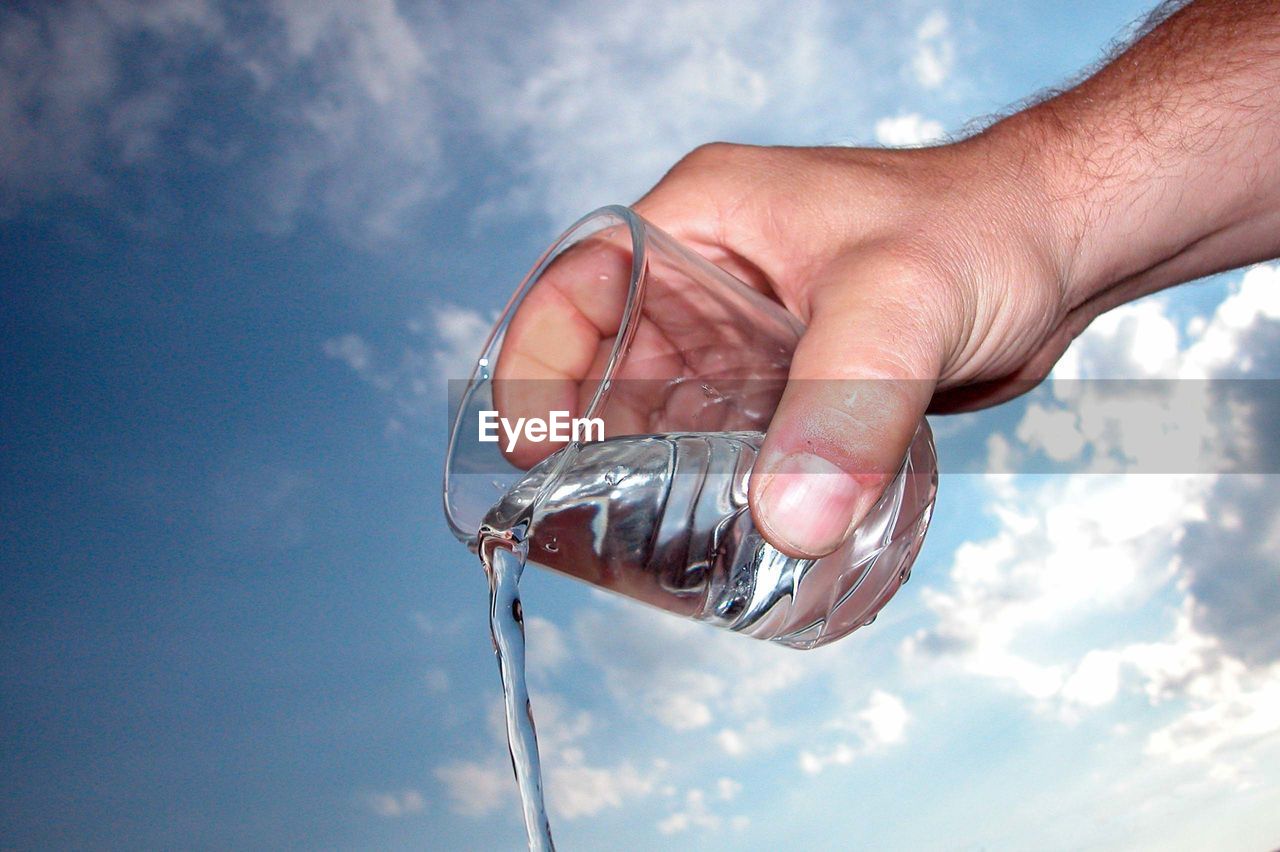 hand, water, cloud, sky, blue, holding, nature, one person, pouring, drinking water, refreshment, adult, outdoors, day, drink, food and drink, bottle, close-up