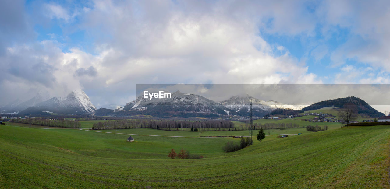 environment, landscape, scenics - nature, mountain, sky, land, cloud, beauty in nature, nature, snow, mountain range, field, grass, grassland, cold temperature, rural scene, tranquility, plain, panoramic, plant, tranquil scene, snowcapped mountain, winter, highland, travel, travel destinations, agriculture, no people, meadow, green, plateau, non-urban scene, tourism, farm, rural area, social issues, valley, pasture, idyllic, environmental conservation, blue, outdoors, day, building, springtime, horizon, prairie, mountain peak, tree, vacation, trip, holiday, architecture, cloudscape, water, road, village