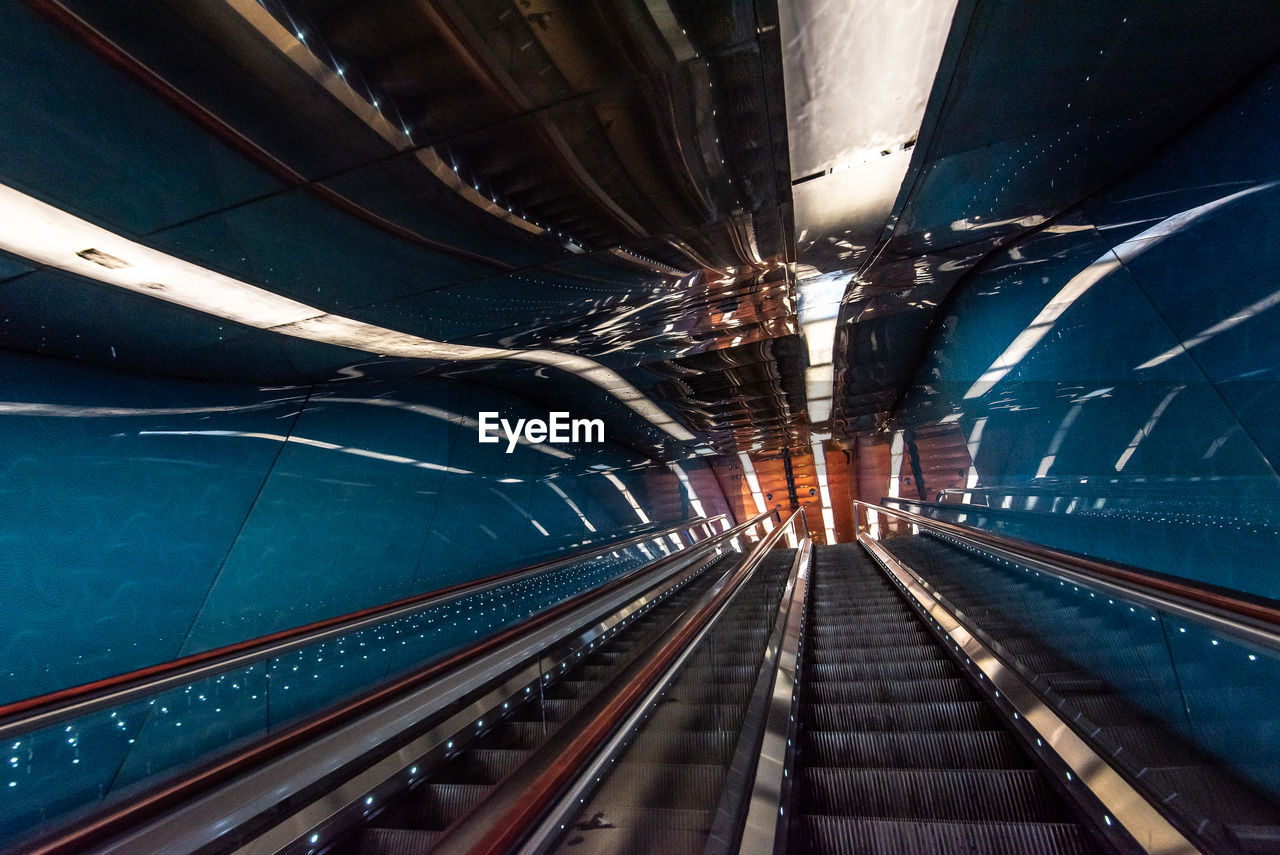 Low angle view of empty escalators with reflection at subway station